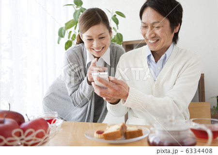 スマートフォンを見る笑顔の中高年夫婦 6334408
