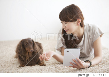 うつ伏せになる女性と犬 6334416