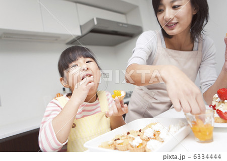 作ったデザートをつまみ食いする笑顔の親子 6334444