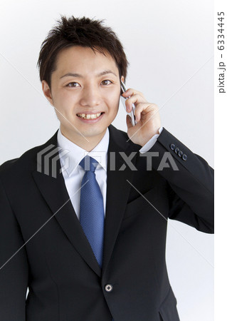 携帯電話で話す笑顔のビジネスマン 携帯電話で話す笑顔のビジネスマン 6334445