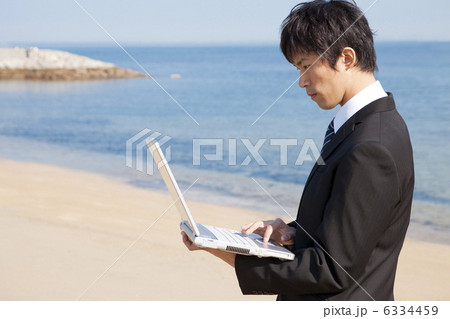 砂浜でパソコンしているビジネスマン 6334459