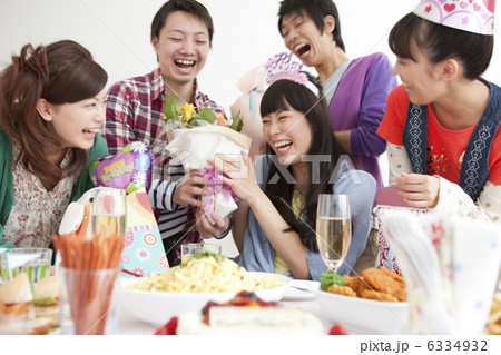 誕生日の女性にプレゼントを渡す男女 誕生日の女性にプレゼントを渡す男女 6334932
