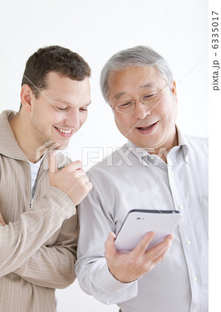 タブレットPCを見る外国人男性と中高年男性 6335017