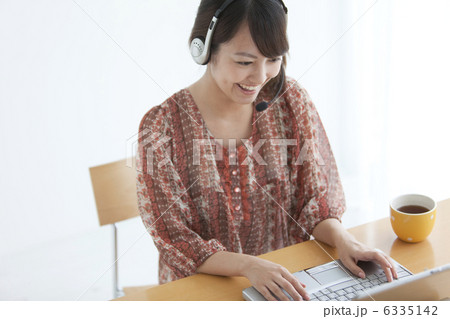 インカムをつけてパソコンを見ている女性 インカムをつけてパソコンを見ている女性 6335142