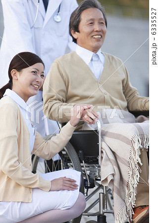 車イスに乗る中高年男性と女性看護師と男性医師 車イスに乗る中高年男性と女性看護師と男性医師 6335527