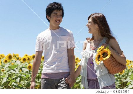 手をつなぐカップルとヒマワリ畑 6335594