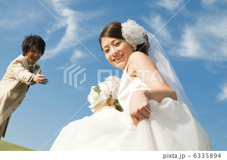 笑顔の新婦と手を差し出す新郎 6335894