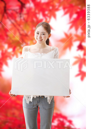 ホワイトボードを持つ女性と紅葉 6339388