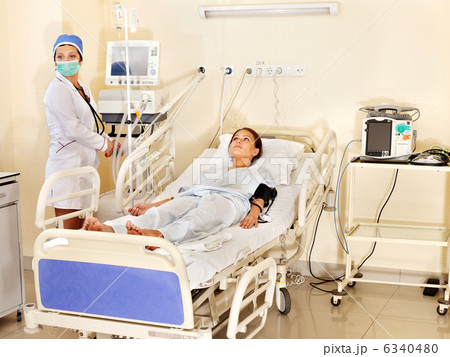 Doctor treats female patient with stethoscope. 6340480