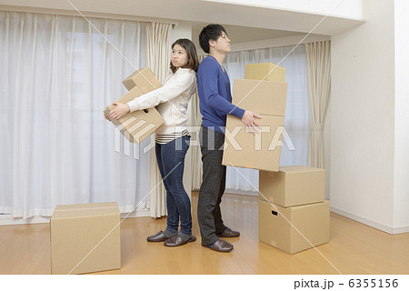 怒った顔で引越し作業する若いカップル 6355156
