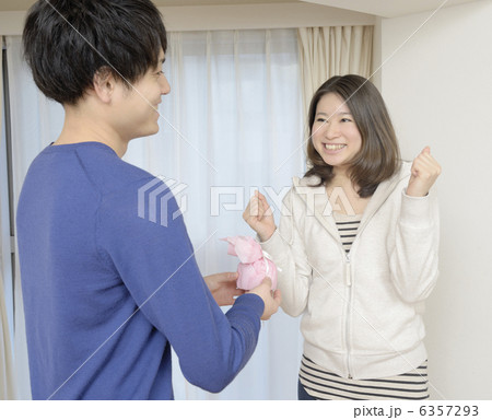 笑顔でプレゼントを渡す若い女性 6357293