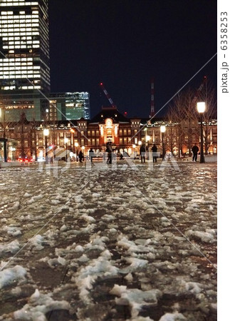 東京の雪の夜景 13 1 15東京駅丸の内駅舎縦位置 行幸通りのシャーベット状の雪の写真素材