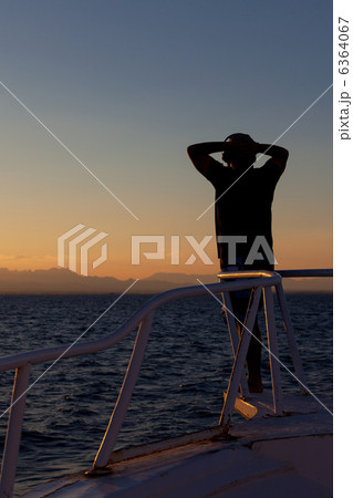 Person enjoying an ocean sunset 6364067