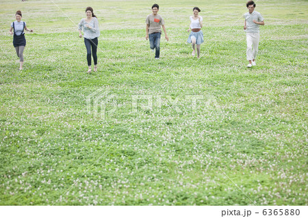 芝生の上を走っている若者5人 6365880