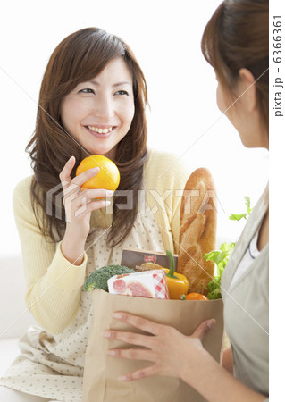 オレンジを持っている笑顔の主婦 6366361