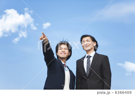 遠くを指差す男子中高生とスーツ姿の父親 6366409
