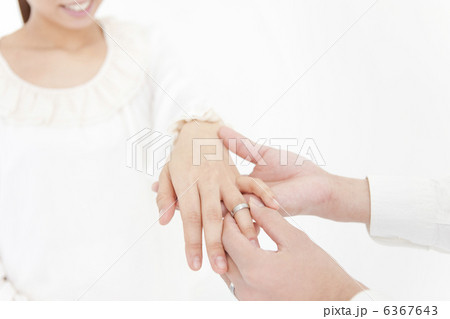 女性の指に指輪をはめる男性の手 6367643