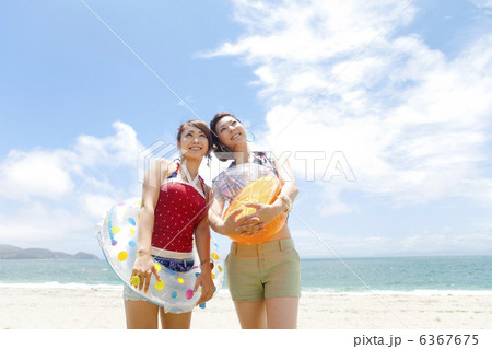 ビーチボールと浮き輪を持った笑顔の女性2人 6367675