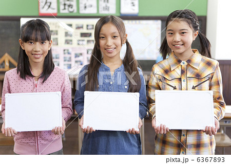 教室でメッセージボードを持っている小学生の女の子3人 6367893
