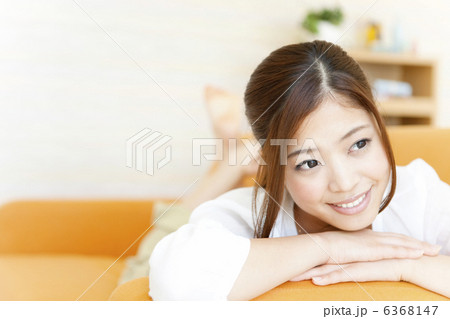 ソファーで寝転ぶ笑顔の女性 ソファーで寝転ぶ笑顔の女性 6368147