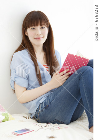 ベッドの上に座って本を持っている女性 6368233