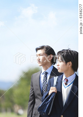 遠くを見ている男子中高生とスーツ姿の父親 6368277