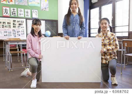 教室でメッセージボードを持っている小学生の女の子3人 6368702