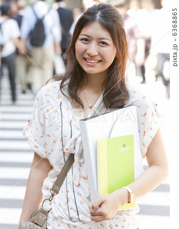 横断歩道を渡る笑顔の女性 6368865