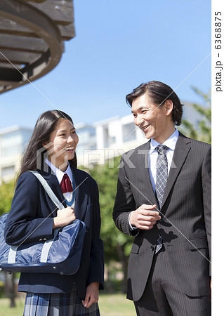 かばんを持っている女子中高生とスーツ姿の父親 かばんを持っている女子中高生とスーツ姿の父親 6368875