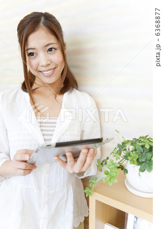 iPadを持っている笑顔の女性 6368877