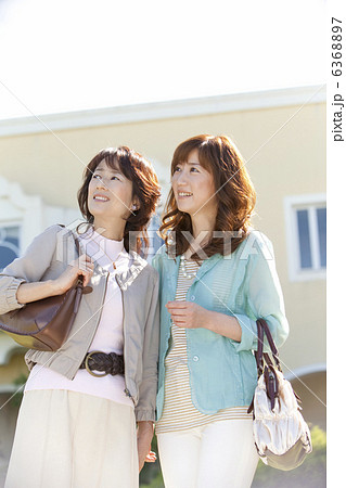 空を見上げている笑顔の女性2人 6368897