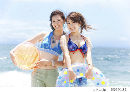 ビーチボールと浮き輪を持っている笑顔の女性2人 6369181