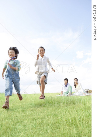 走っている子供と見守る両親 走っている子供と見守る両親 6371378