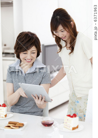 タブレットPCを見て話をする女性2人 6371963