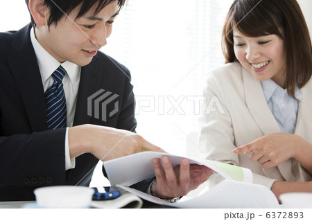 打ち合わせをするビジネスマンとビジネスウーマン 打ち合わせをするビジネスマンとビジネスウーマン 6372893