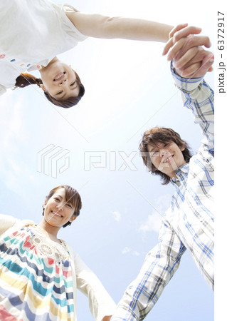 手をつないで輪になる若者3人 手をつないで輪になる若者3人 6372917