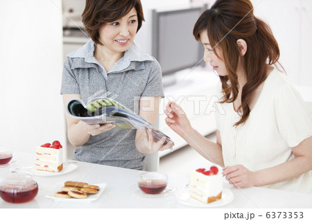 雑誌を見て話をする女性2人 6373353