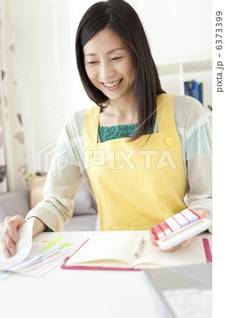 家計簿をつけている笑顔の女性 6373399