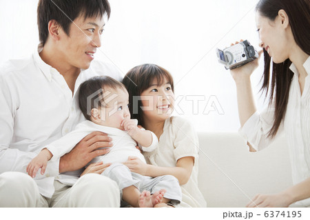 ビデオを撮る母親と父親と子供2人 6374195