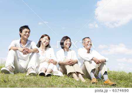 芝生に座る家族4人 6374690