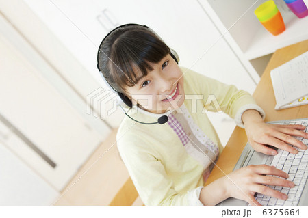 インカムをつけてパソコンに向かう女の子 インカムをつけてパソコンに向かう女の子 6375664