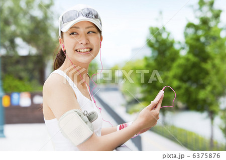 スポーツウェア姿で携帯を持つ女性 6375876