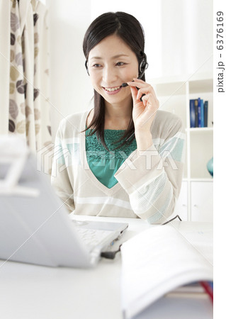 インカムをつけて会話している笑顔の女性 6376169
