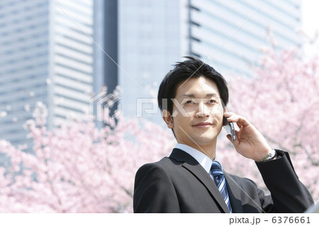 桜の前で電話するビジネスマン 桜の前で電話するビジネスマン 6376661