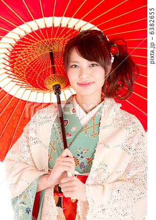 和服に肩掛けを羽織り和傘をさす美しい日本人の写真素材