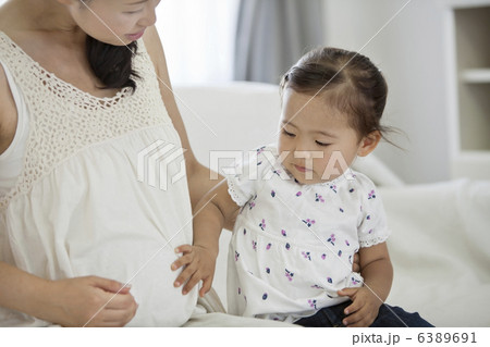 妊婦のお腹を触る女の子 6389691