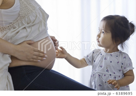 妊婦のお腹を触る女の子 6389695