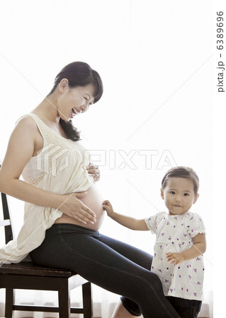 妊婦のお腹を触る女の子 6389696