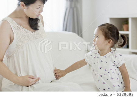 妊婦のお腹を触る女の子 6389698
