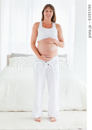 Beautiful pregnant female posing while standing Beautiful pregnant female posing while standing 6395590